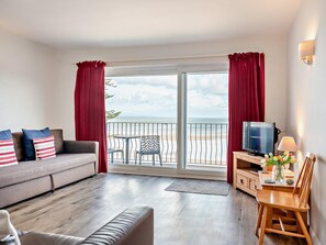 A living room with a sofa, TV, and a table with a lamp. - 1 Bed in Saundersfoot (oc-fb298) (Saundersfoot)