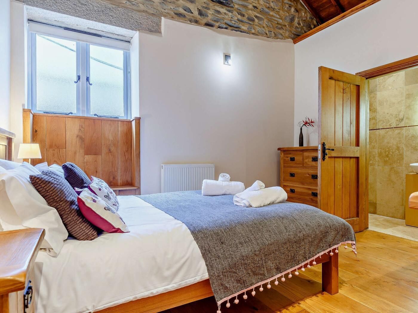 Ein Schlafzimmer mit einem Bett, einem Holzschrank und einem Fenster.