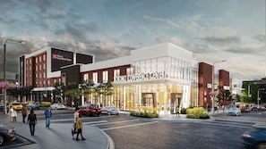 A modern building with a prominent 'Kokomo Conference Center' sign, surrounded by a parking lot and a street with pedestrians. - Hilton Garden Inn Kokomo Downtown (Kokomo)