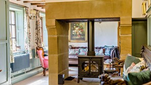 A cozy living room with a fireplace, a sofa, and a radiator. - 7 Bed in Stoke-on-trent (oc-81529) (Waterhouses)