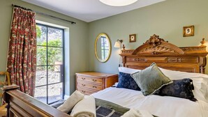 A bedroom with a large bed, a dresser, a nightstand, a mirror, and a window with curtains. - 7 Bed in Stoke-on-trent (oc-81529) (Waterhouses)