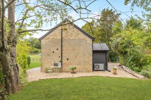 A brick building with a small attached shed, surrounded by a well-maintained lawn and trees. - 1 Bed in Little Gransden (oc-81056) (Little Gransden)