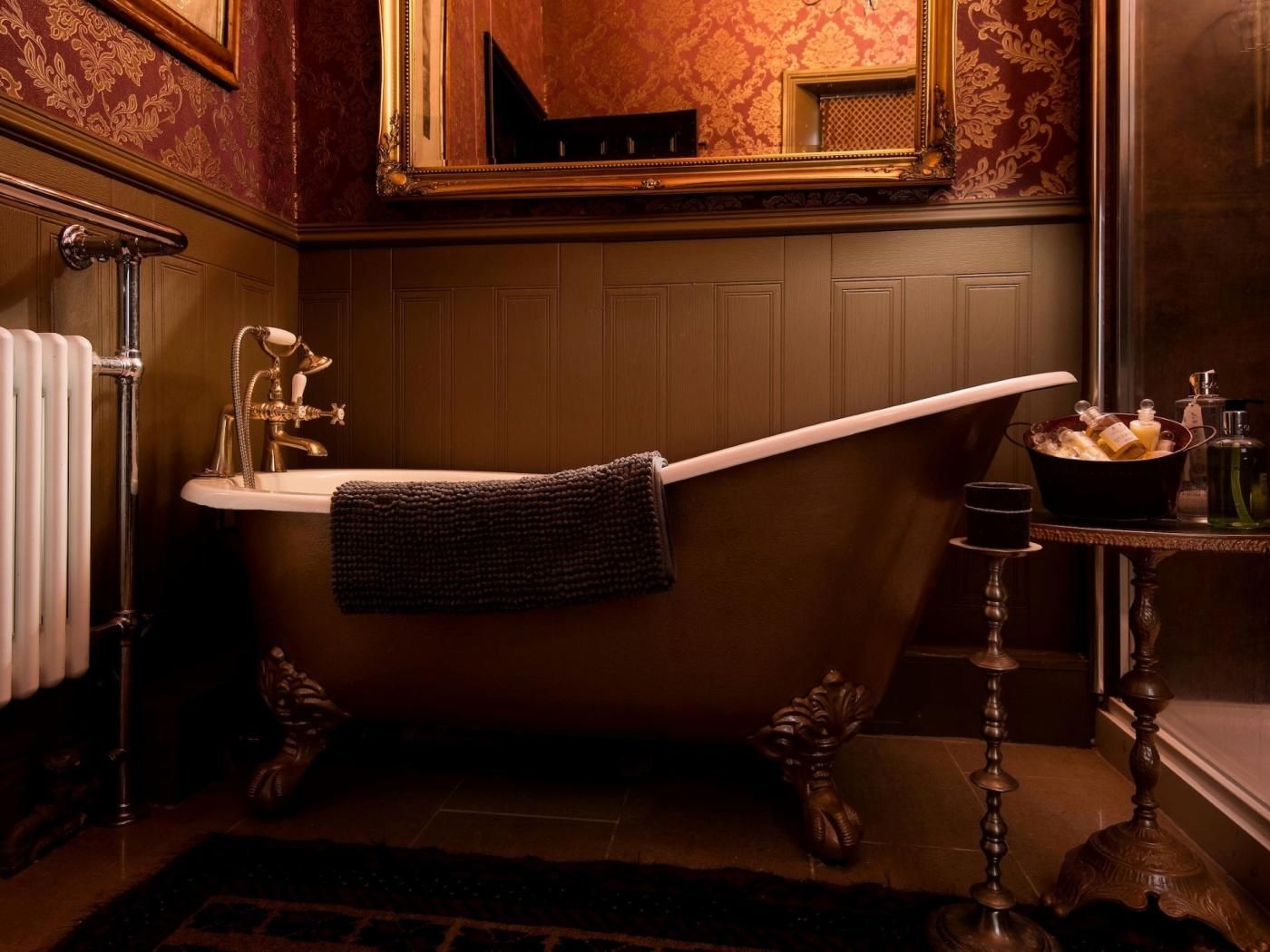 Un bagno classico con una vasca freestanding, un lavandino bianco e uno specchio sopra.
