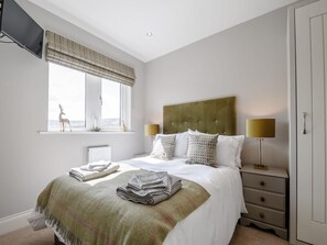 A bedroom with a bed, a window with a view, a bedside table, and a wardrobe. - 1 Bed in Holmfirth (oc-82194) (Meltham)