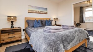 A bedroom with a bed, bedside tables, a lamp, a painting, and a window. - 1 Bed in Norwich (oc-82230) (Mundesley)