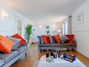 A living room with two sofas, a coffee table, and a bookshelf.