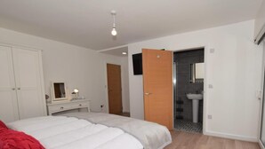 A bedroom with a bed, a dresser, a mirror, and a bathroom visible through an open door. - 4 Bed in Chathill (oc-82235) (Beadnell)