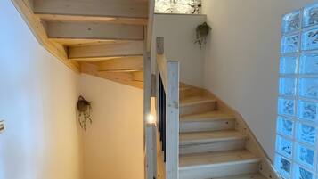 Una escalera de madera con un muro de bloques de vidrio a un lado.
