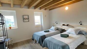 Une chambre avec deux lits, un bureau et une chaise.