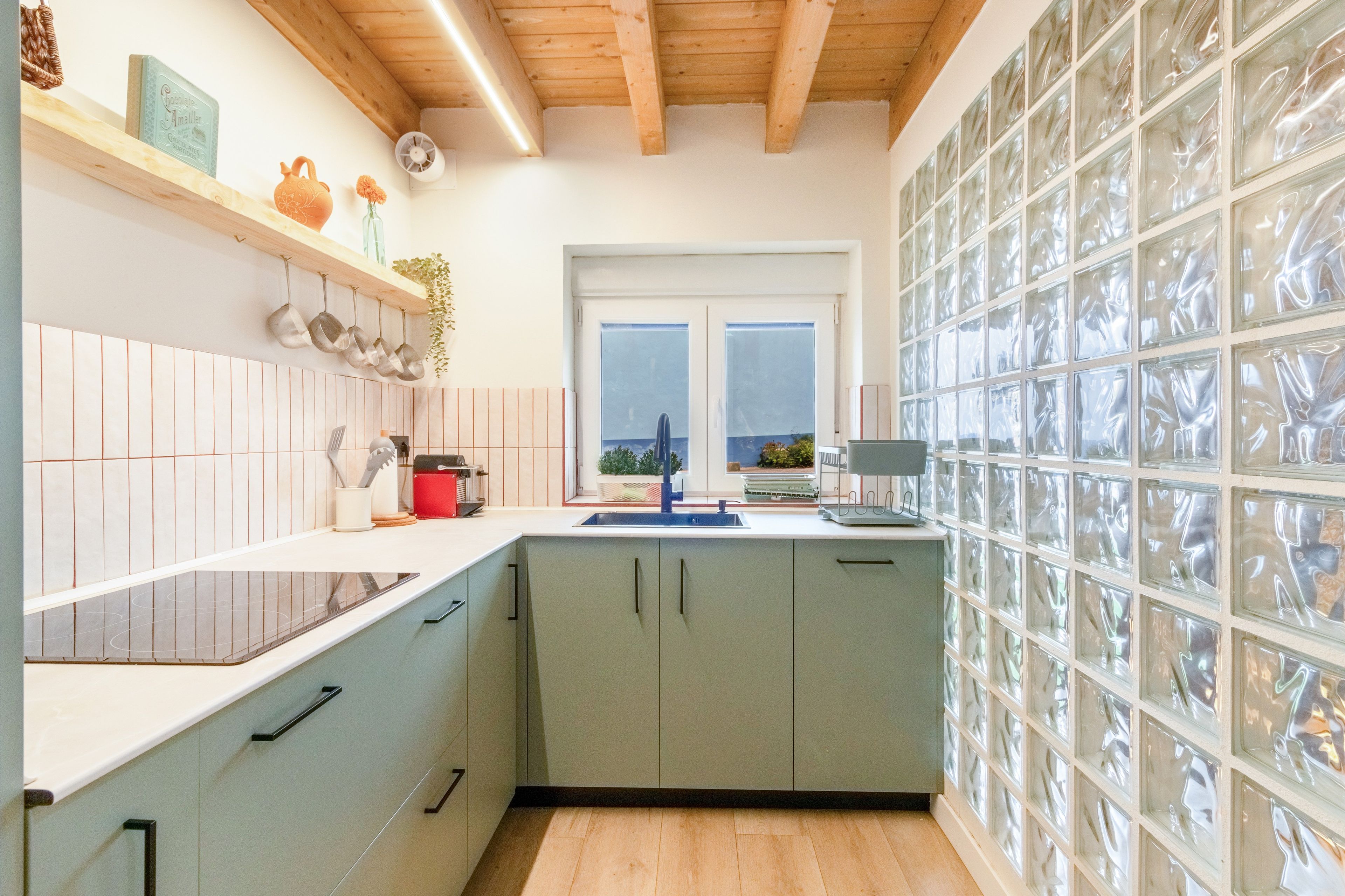 Una cocina con ventana, armarios y encimera.