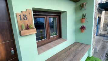 Fachada moderna con banco de madera, ventana con vistas y una puerta.