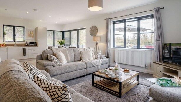 A modern living room with a grey sofa, a coffee table, and a TV. - 2 Bed in Usk- (oc-82391) (Kemeys Commander)