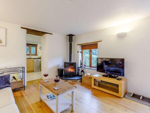 Ein gemütliches Wohnzimmer mit Kamin, Fernseher und Essbereich.