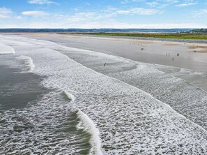 A beach with waves, a sandy shore, and a distant landscape. - 1 Bed in Bideford (oc-82381) (Westward Ho!)