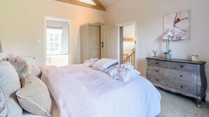 Ein Schlafzimmer mit einem Bett, einem Schminktisch und einem Bild an der Wand.