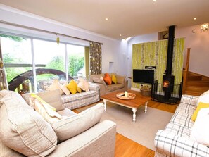 Ein modernes Wohnzimmer mit Sofa, Couchtisch und Kamin.