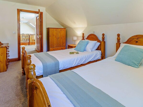 A bedroom with two wooden beds, a wooden wardrobe, and a mirror. - 6 Bed in Llandovery (oc-82441) (Llanfair-ar-y-Bryn)