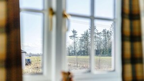 A window with a view of a rural landscape, including trees and a field. - 2 Bed in Berwick-upon-tweed (oc-81273) (Berwick-upon-Tweed)