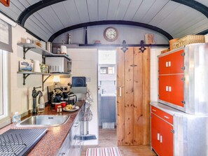 A compact kitchen with a sink, stove, and cabinets.
