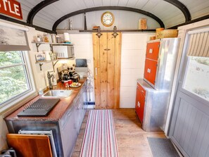 A compact kitchen with a wooden door, a sink, and a refrigerator. - 1 Bed in Harrogate (oc-81300) (Clint)