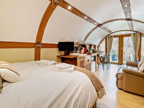 A cozy, circular room with a bed, a desk, and a chair.