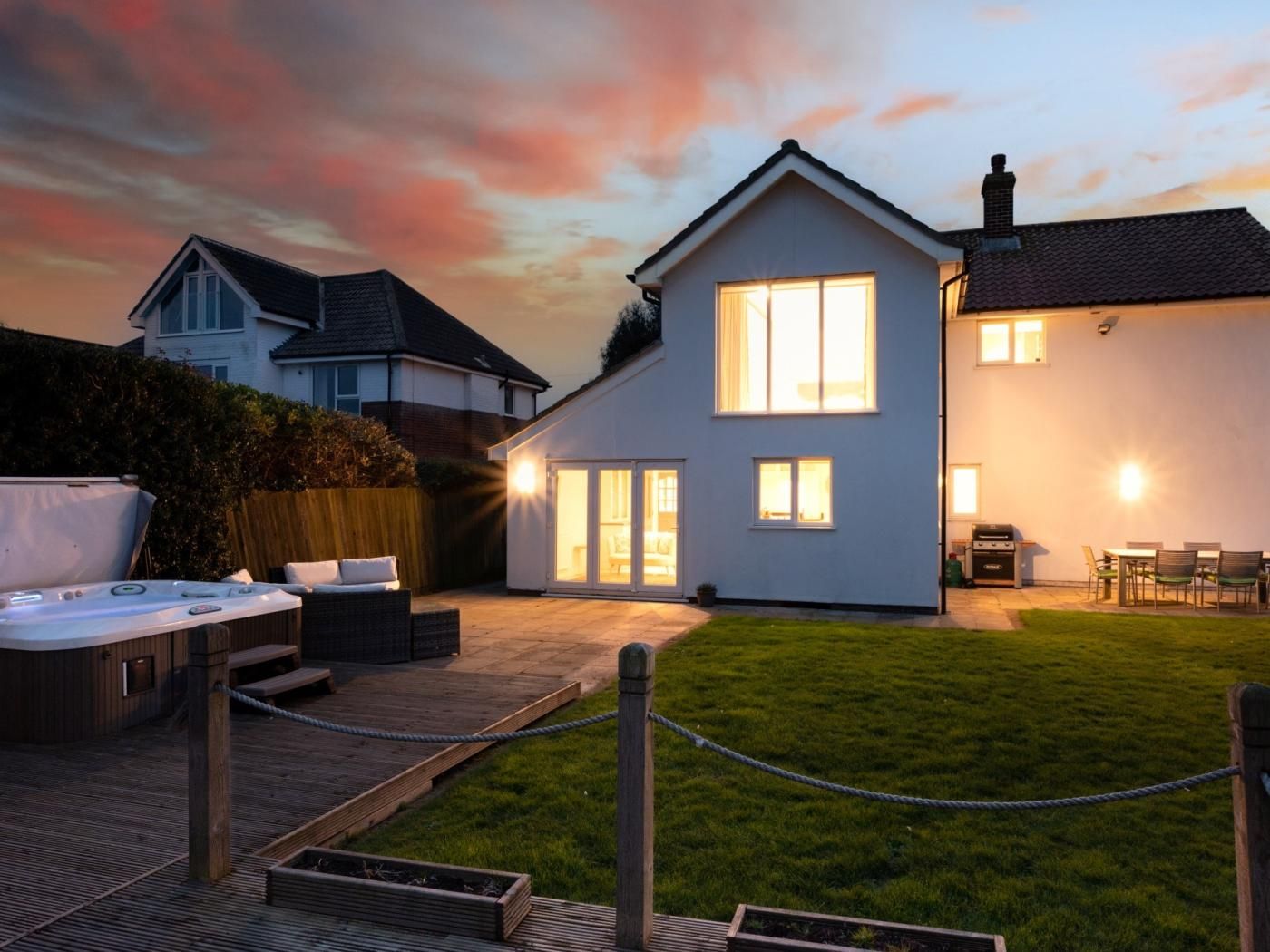 A residential property with a patio, outdoor seating, and a hot tub.