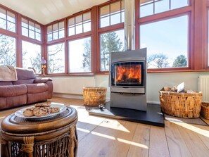 A cozy room with a fireplace, a sofa, and wicker baskets. - 5 Bed in West Linton (oc-81467) (West Linton)