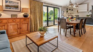 A modern kitchen with a dining area, wooden cabinets, and a large window. - 2 Bed in Hereford (oc-82095) (Lulham)