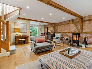 A cozy living room with a fireplace, wooden beams, a sofa, a desk, and a dining area. - 2 Bed in Hereford (oc-82095) (Lulham)