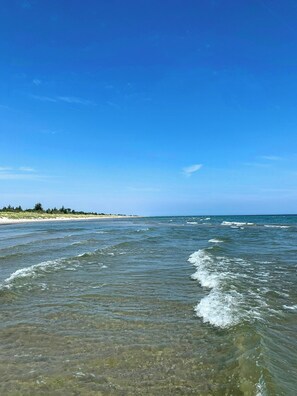 A beach with clear water and a distant shoreline. - New timber house with cozy terrace near the beach (Hals)