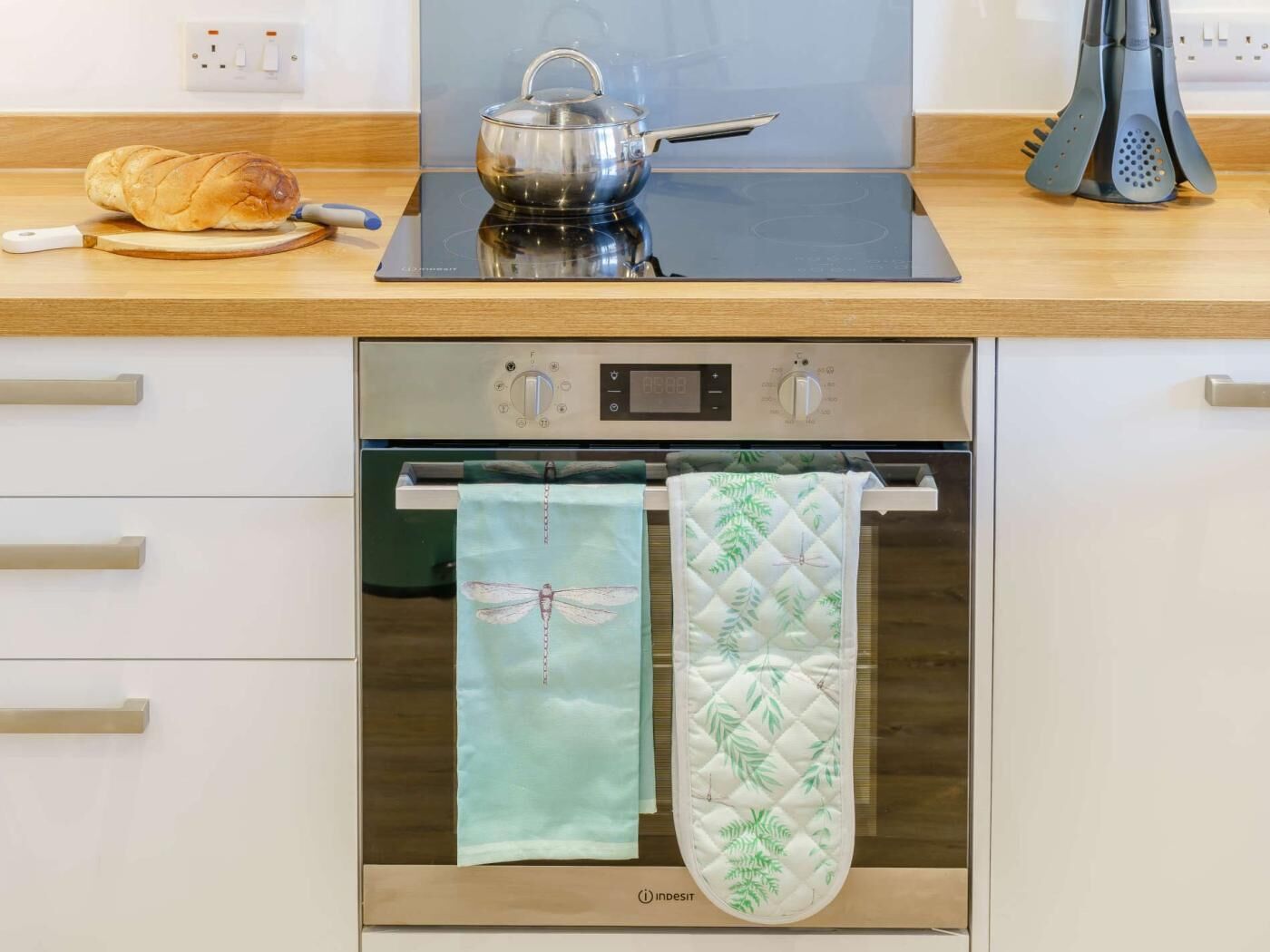 A kitchen with a bread loaf, a kettle, and a coffee maker on the counter.