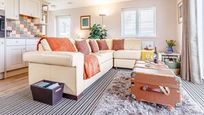 A living room with a sofa, a rug, a suitcase, and a plant. - 1 Bed in Bude (oc-82365) (Jacobstow)
