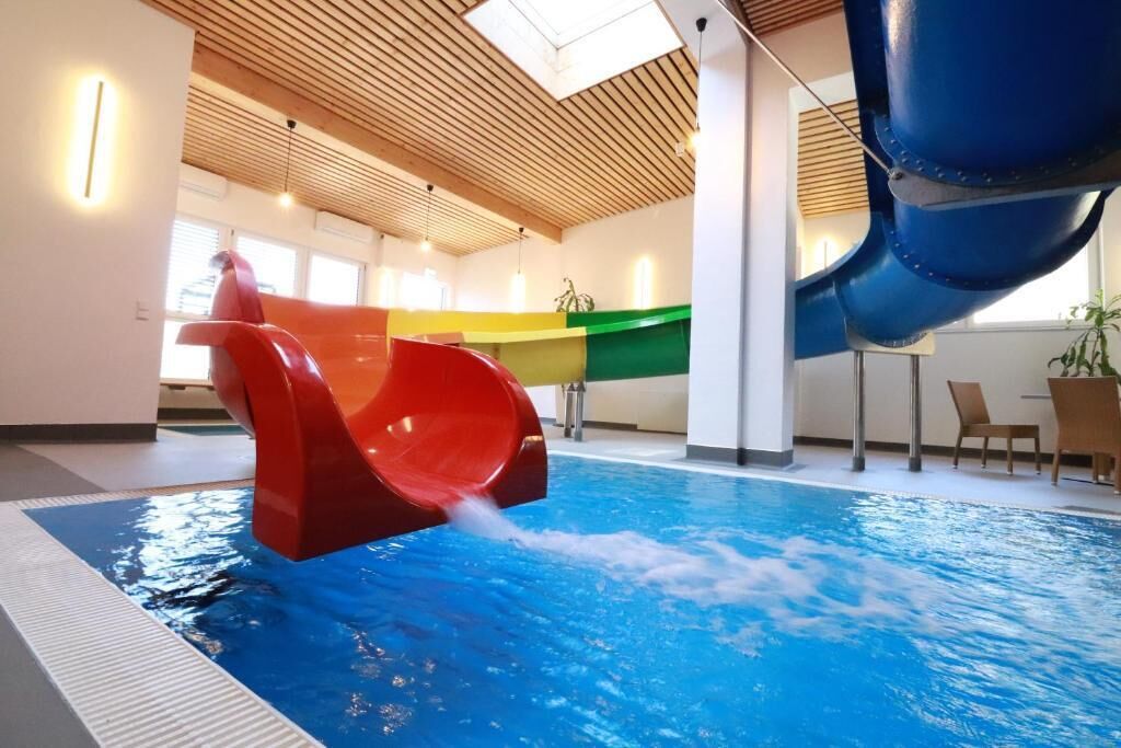 An indoor swimming pool with a water slide.