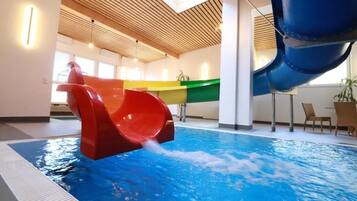 An indoor swimming pool with a water slide.