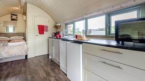 A cozy room with a bed, a kitchen area with a microwave, and a window with a view. - 1 Bed in Hereford (oc-81292) (Aconbury)