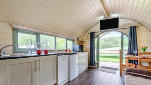 A compact kitchen with a window, a flat-screen TV, and a dining area with a table and chairs. - 1 Bed in Hereford (oc-81292) (Aconbury)