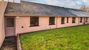 A single-story building with a sloped roof, a front door, and multiple windows. - 3 Bed in Pembroke (oc-fb316) (Lamphey)