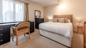 A bedroom with a bed, a dresser, a chair, a bedside table, and a window with curtains. - 3 Bed in Pembroke (oc-fb316) (Lamphey)