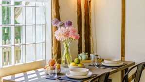 A dining table with plates, bowls, and a vase with flowers. - 1 Bed in Ashford (oc-82527) (Biddenden)