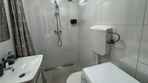 Ein Badezimmer mit Dusche, Toilette und Waschbecken.