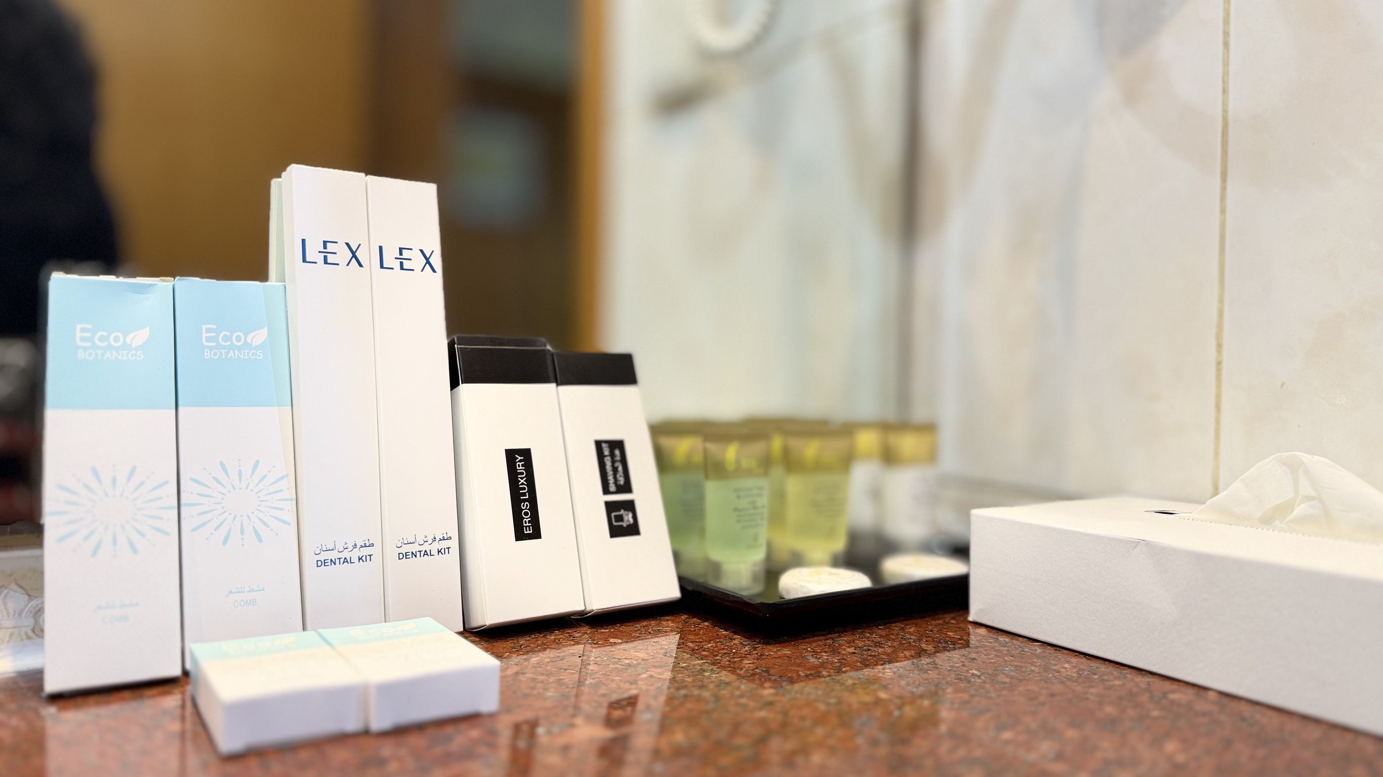 A countertop with various items including boxes labeled 'LEX LEX' and 'Eros Luxury,' a tissue box, and a tray with small containers.