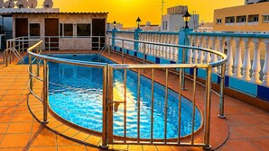 A rooftop swimming pool with a sunlit sky in the background. - Elite Jonrad Hotel (Dubai)