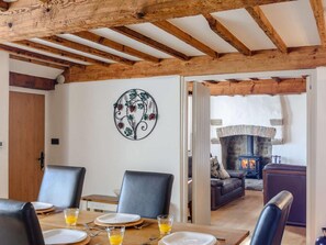 Uma área de refeições com uma mesa de madeira, cadeiras e um painel decorativo de metal.