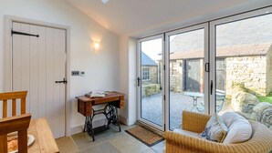 A room with a skylight, a wooden desk, a wicker chair, and a sliding glass door leading to an outdoor area. - 3 Bed in Bedale (oc-81375) (Hackforth)