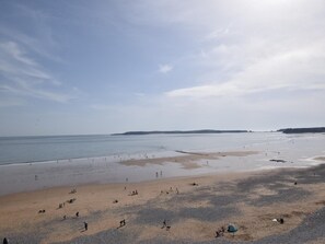 A wide beach with people scattered across the sand and water. - 2 Bed in Tenby (oc-82226) (Tenby)