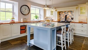Een moderne keuken met een centraal eiland, witte kasten en een groot raam.