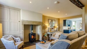 A cozy living room with a fireplace, comfortable seating, and a view into the kitchen. - 2 Bed in Grange-over-sands (oc-82672) (Cartmel)