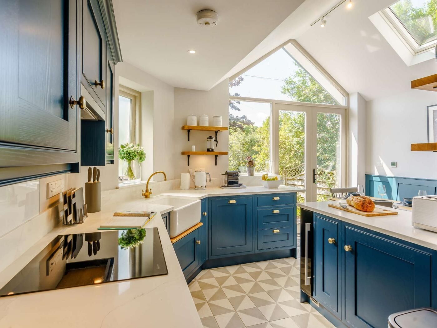 A modern kitchen with a large island, built-in appliances, and a view of the outdoors.