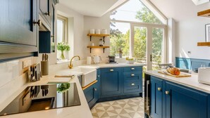 A modern kitchen with a large island, built-in appliances, and a view of the outdoors. - 2 Bed in Grange-over-sands (oc-82672) (Cartmel)