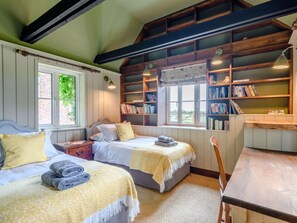 A room with two beds, a wooden table, a bookshelf, and a window. - 4 Bed in Salisbury (oc-82799) (Winchester)